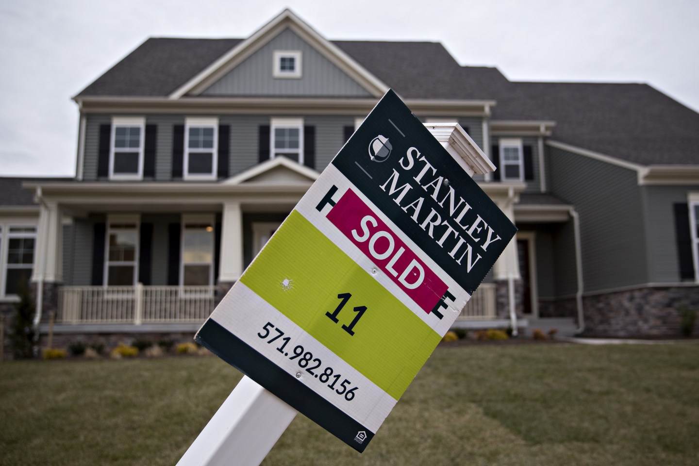 Photo of house with "sold" sign out front.