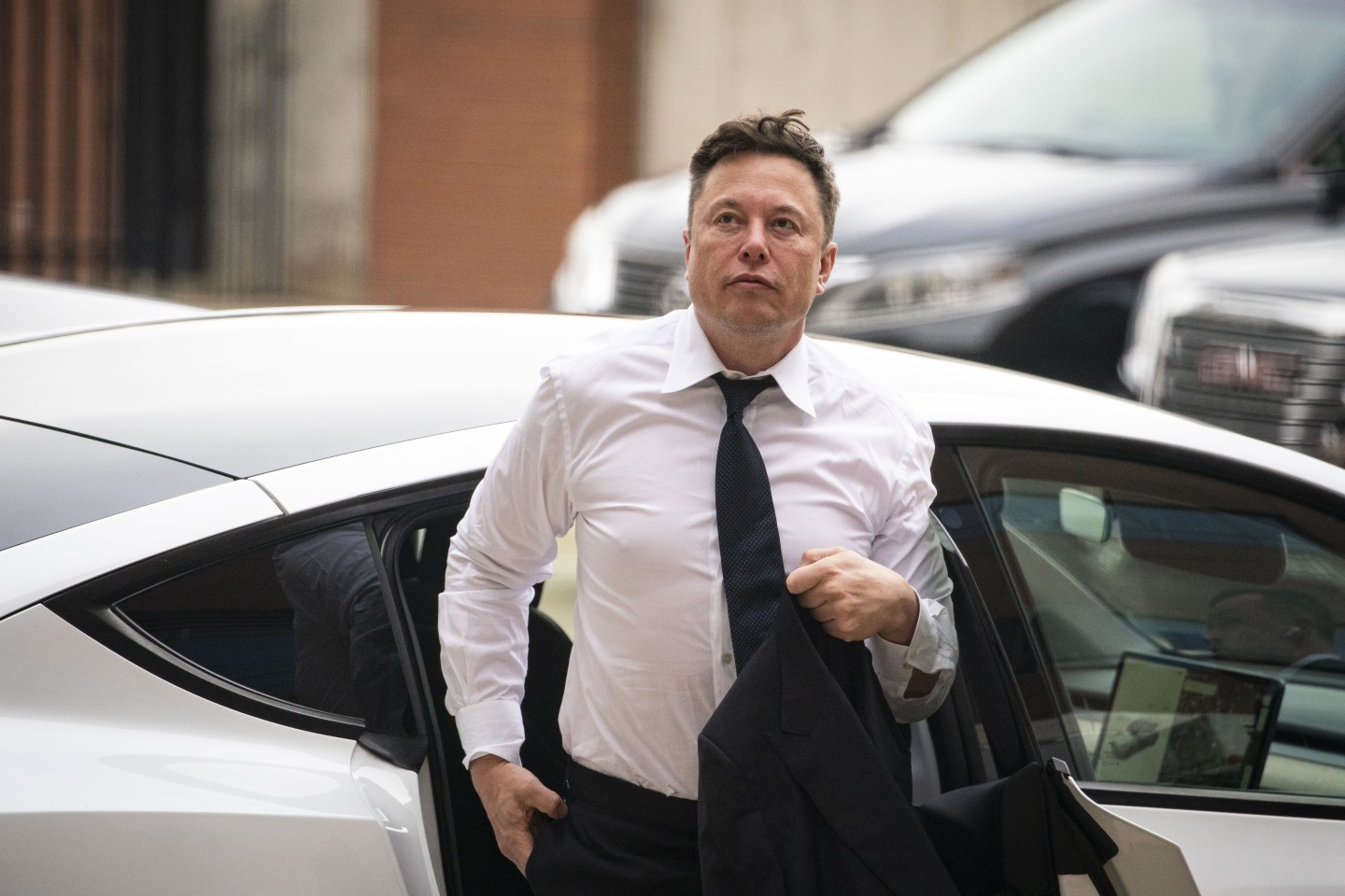 Elon Musk coming out of a car