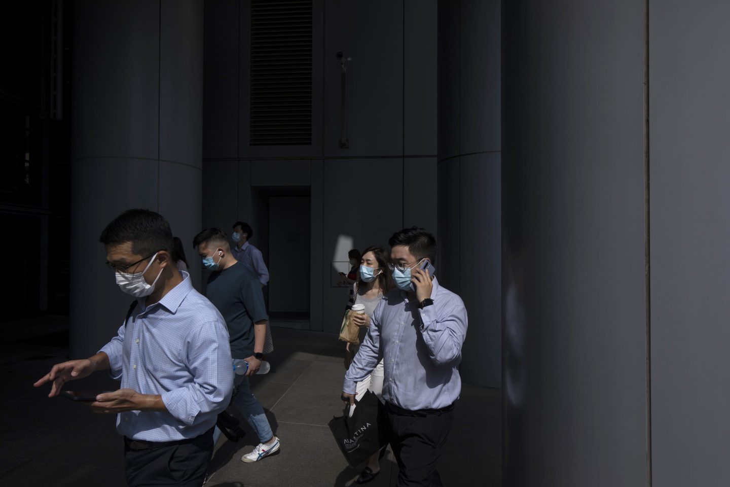 Morning commuters wearing protective masks make their way through Central district in Hong Kong, China, on Wednesday, Aug. 18, 2021. Hong Kong is caught between its desire to reopen and the government&#8217;s zero tolerance for any cases of Covid-19, which has kept the virus out for most of the pandemic. Photographer: Paul Yeung/Bloomberg via Getty Images