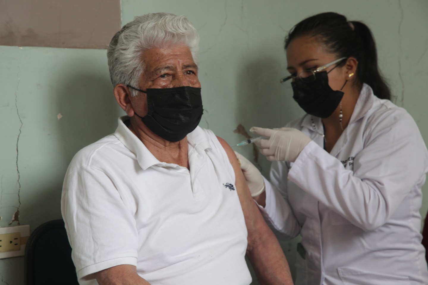 A health worker administers the third dose of the AstraZeneca vaccine to a senior citizen as part of the vaccination campaign on November 8, 2021 in Cuenca, Ecuador.