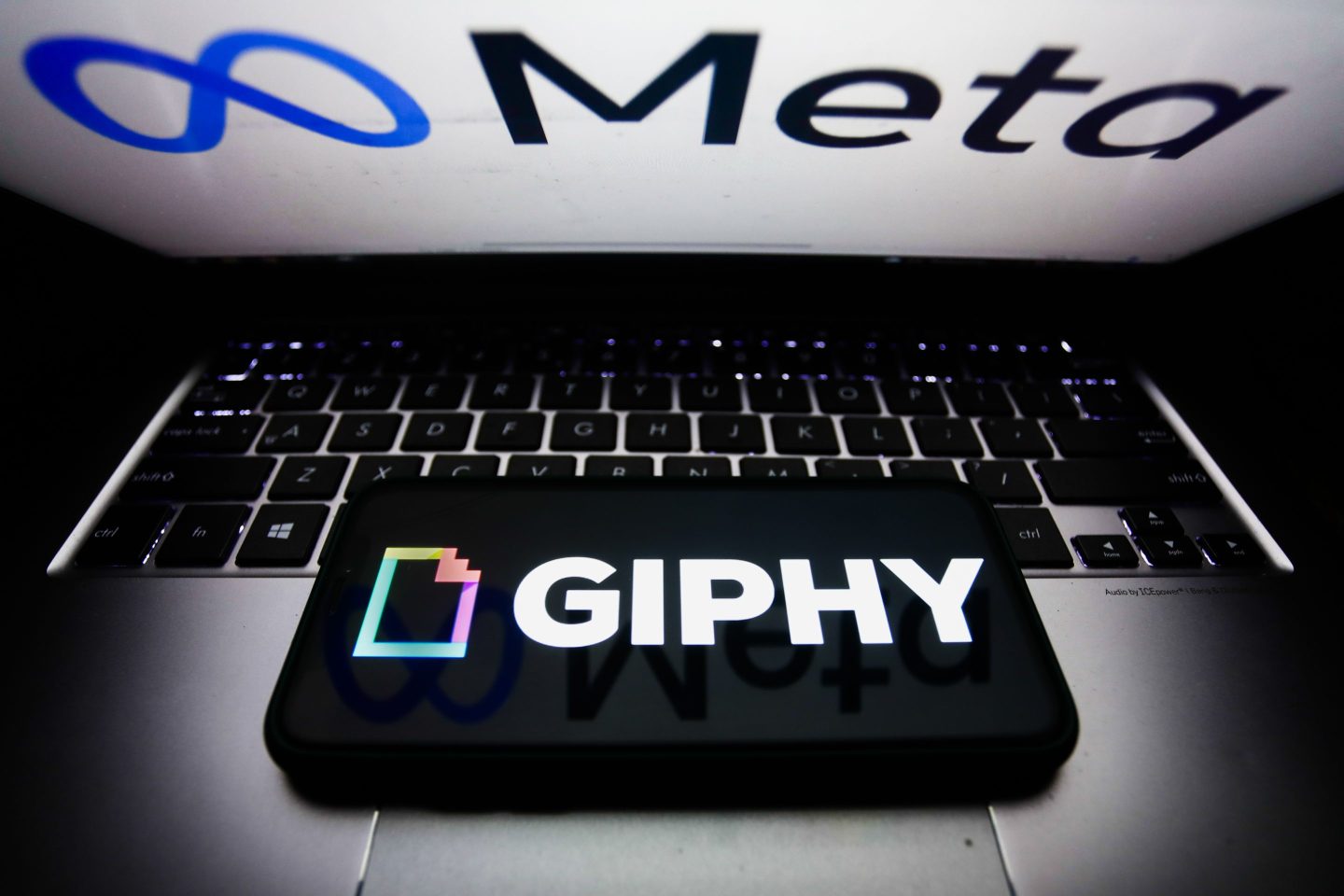 Giphy logo displayed on a phone screen and Meta logo displayed on a laptop screen are seen in this illustration photo taken in Krakow, Poland on November 29, 2021