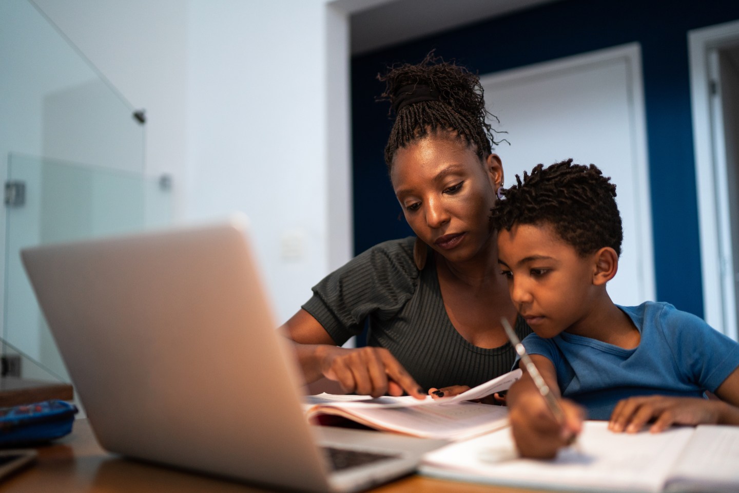 Photo of mother helping son with homework at home