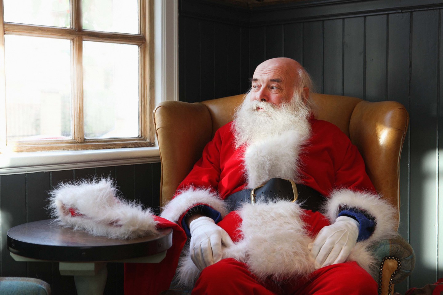 Photo of Santa Claus sitting in chair with hat off