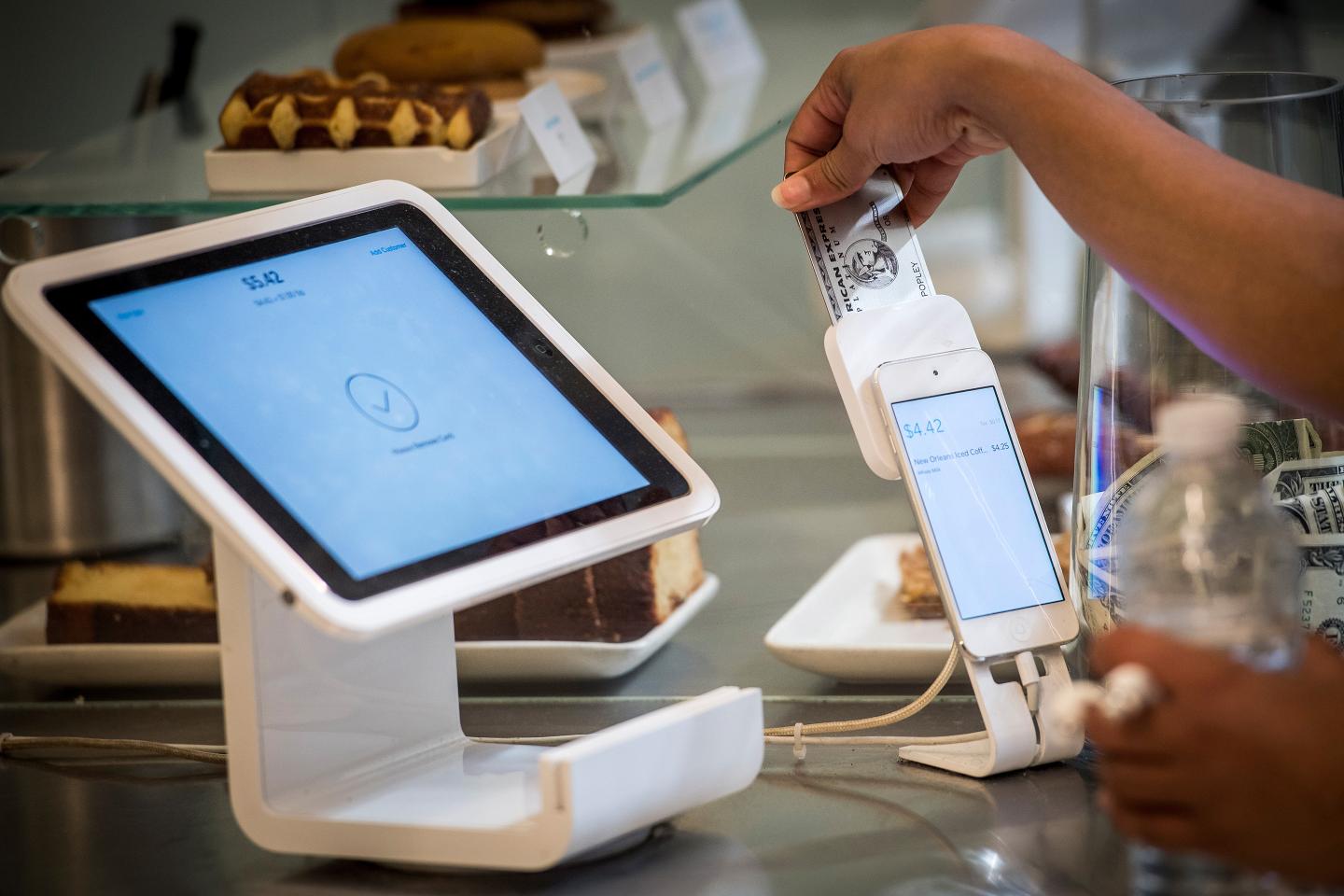 A customer removes a credit card into Square Inc. device while making a payment in San Francisco, California.