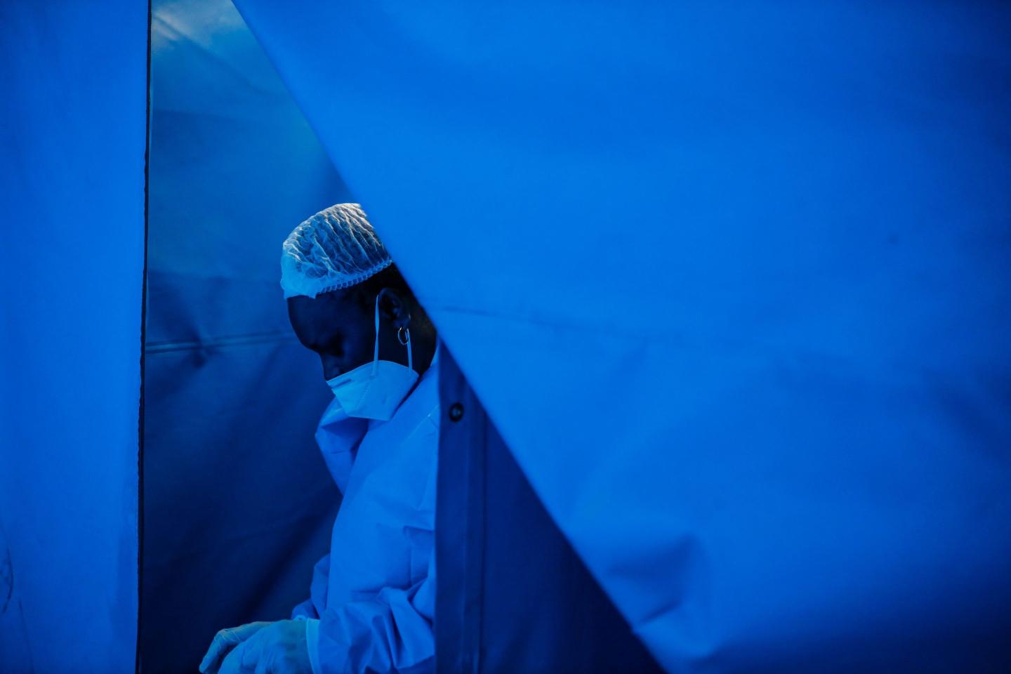 A nurse in South Africa puts on her protective equipment.