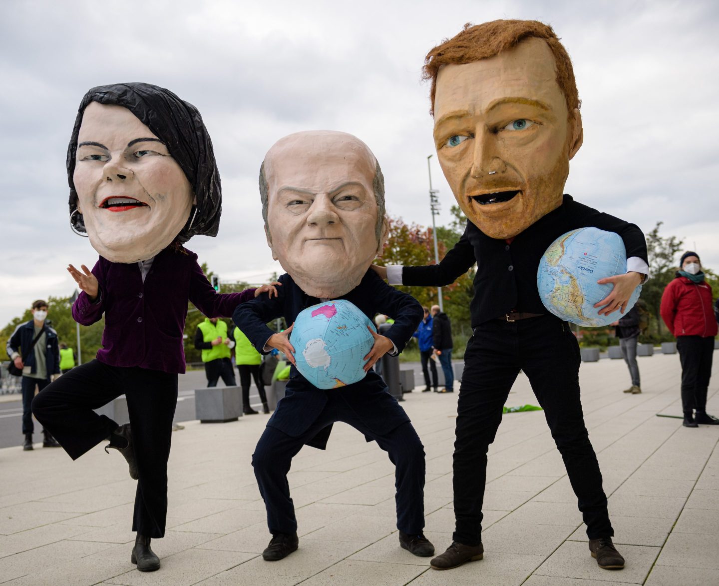Climate protesters wearing masks of (from left) Green Party coleader Annalena Baerbock, the Social Democratic Party’s (SPD) Olaf Scholz, and Free Democratic Party (FDP) leader Christian Lindner on Oct. 15 in Berlin.