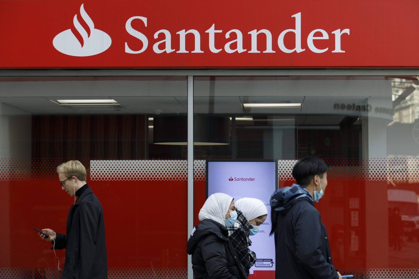 People walk by a Santander bank branch
