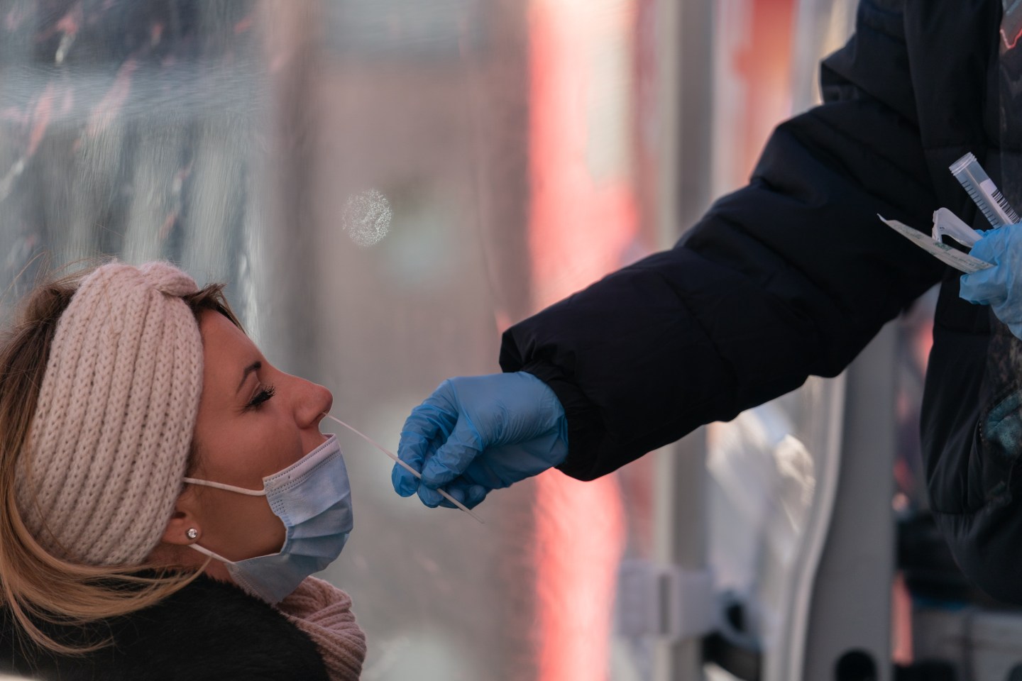 A health care worker administers a nasal swab test for COVID.