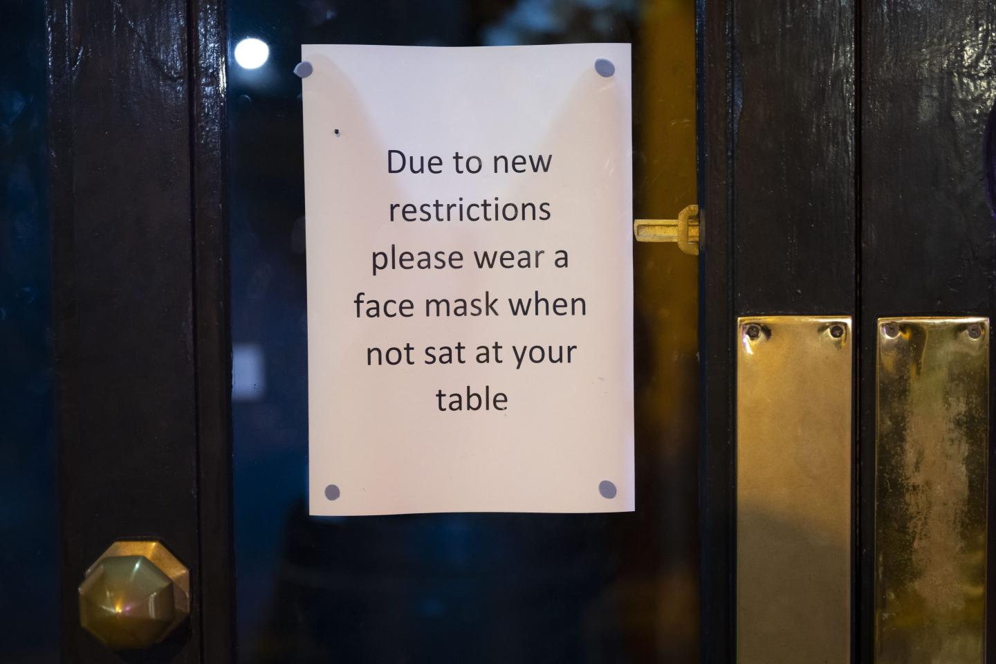 Sign saying that customers must wear masks when not seated at the table at a restaurant in Wales
