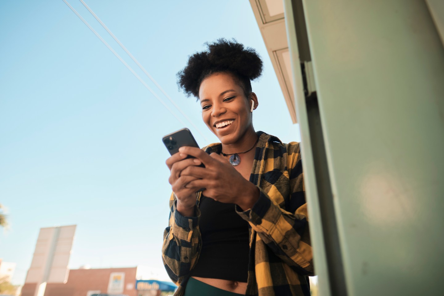 Woman laughing while looking at something funny on her phone screen.