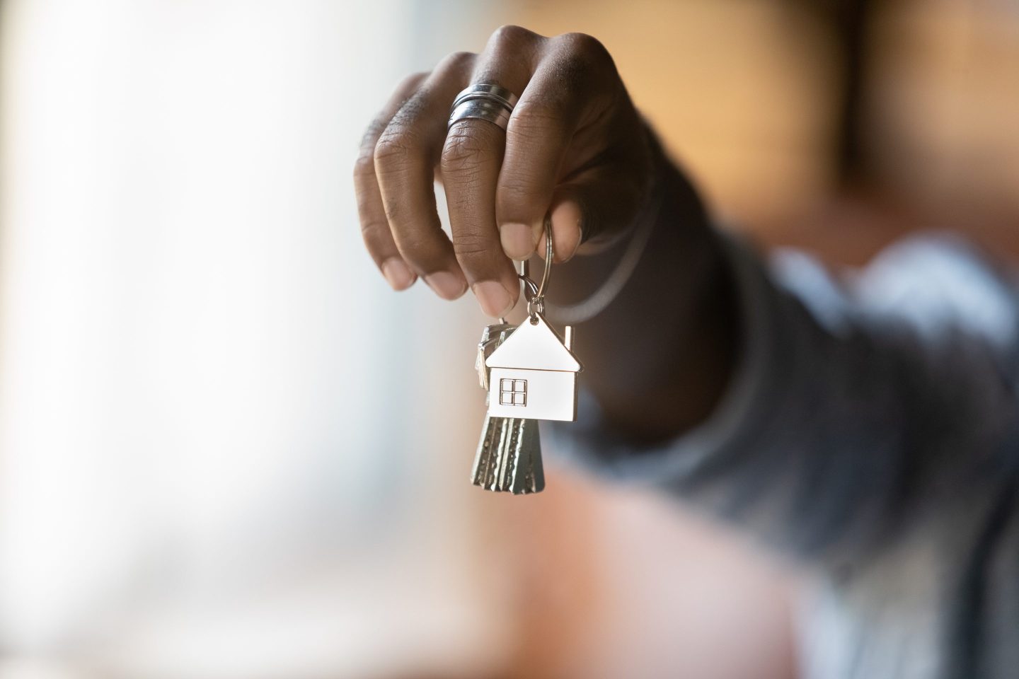 Closeup of young Black man's hand holding housekeys