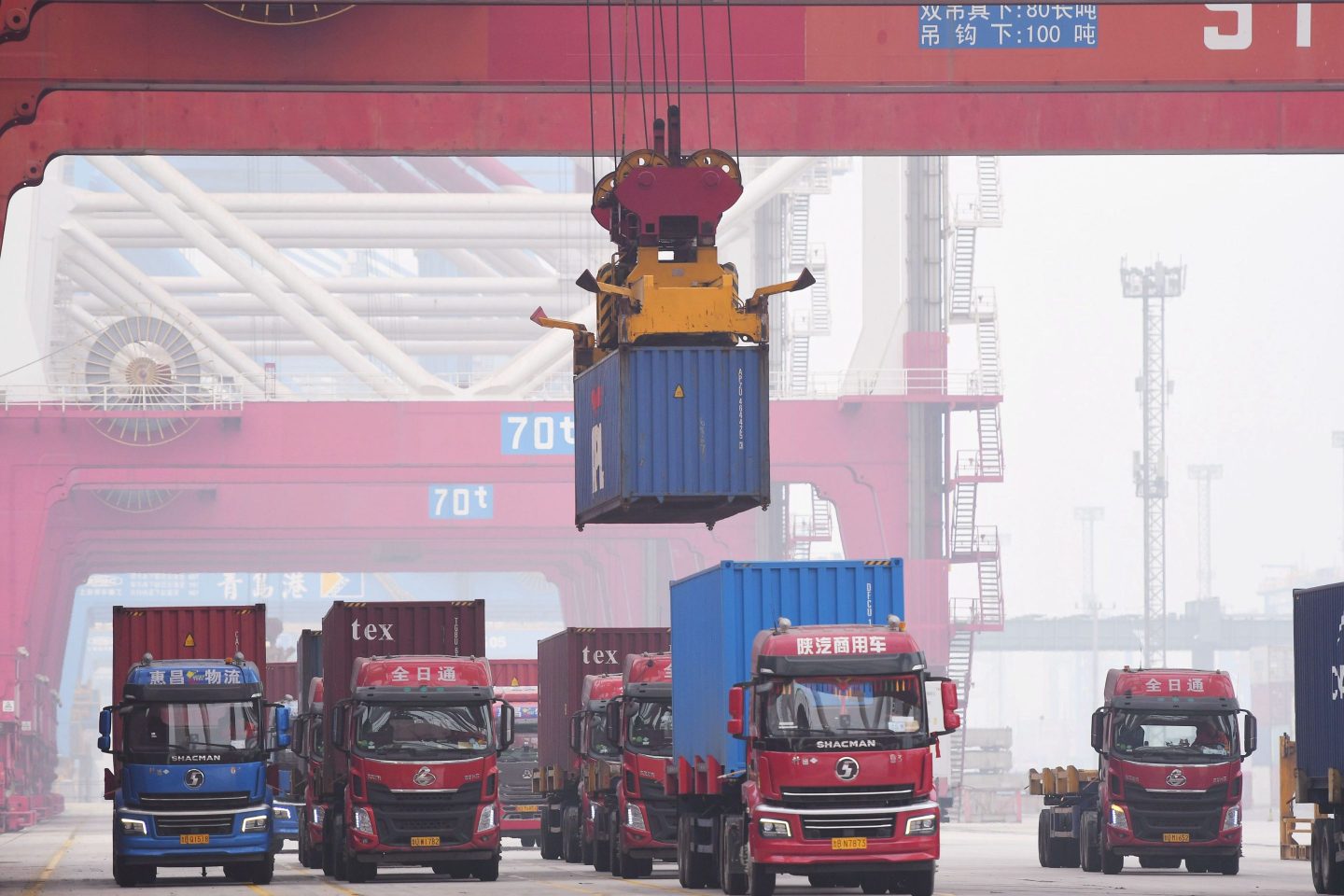 QINGDAO, CHINA &#8211; DECEMBER 23: Shipping containers are loaded onto trucks after a ceremony to celebrate Shandong Port Group Co Ltd&#8217;s annual cargo throughput exceeding 1.5 billion metric tons at Qingdao Port on December 23, 2021 in Qingdao, Shandong Province of China. (Photo by Yu Fangping/VCG via Getty Images)