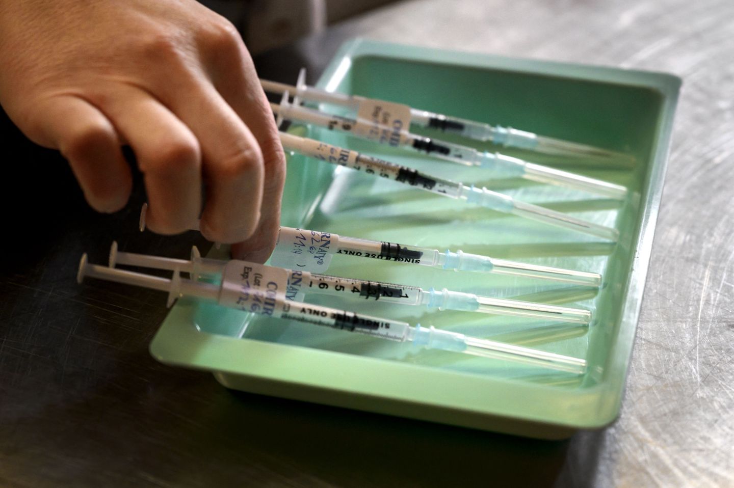 A soldier in Switzerland prepares vaccine doses.