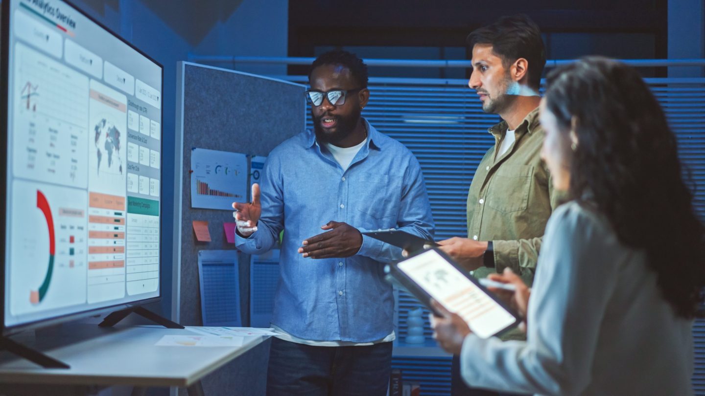 Team of developers reviews data on a screen.
