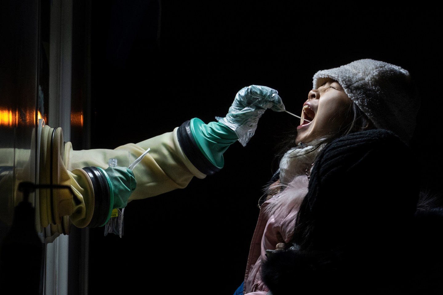 A young girl is given a nucleic acid test for COVID-19 by a health worker at a private testing site on January 13, 2022 in Beijing, China.
