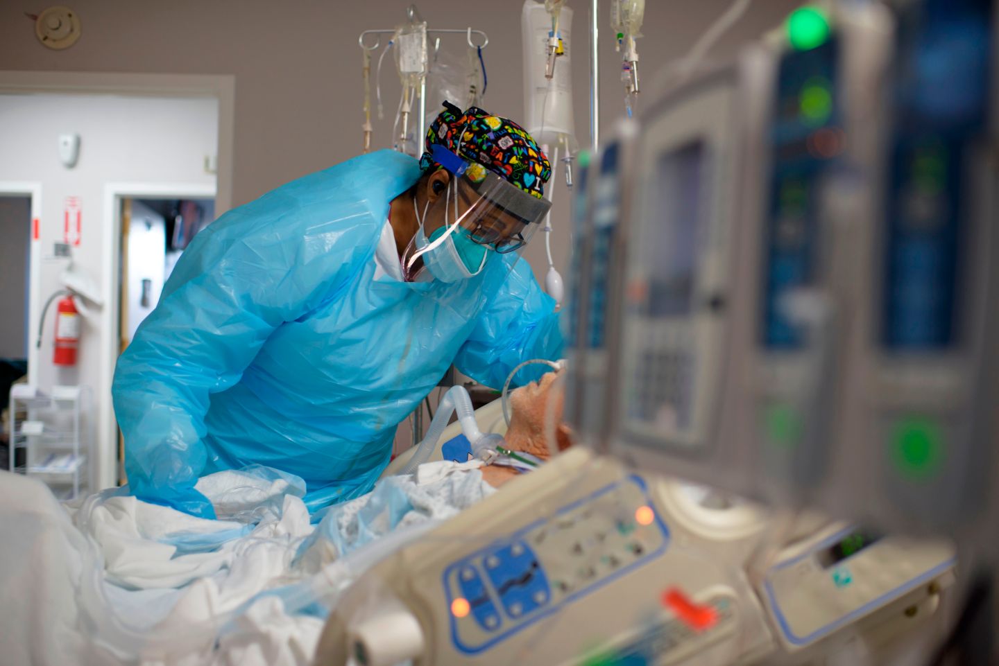 A health care worker comforts a COVID-19 patient in Houston.