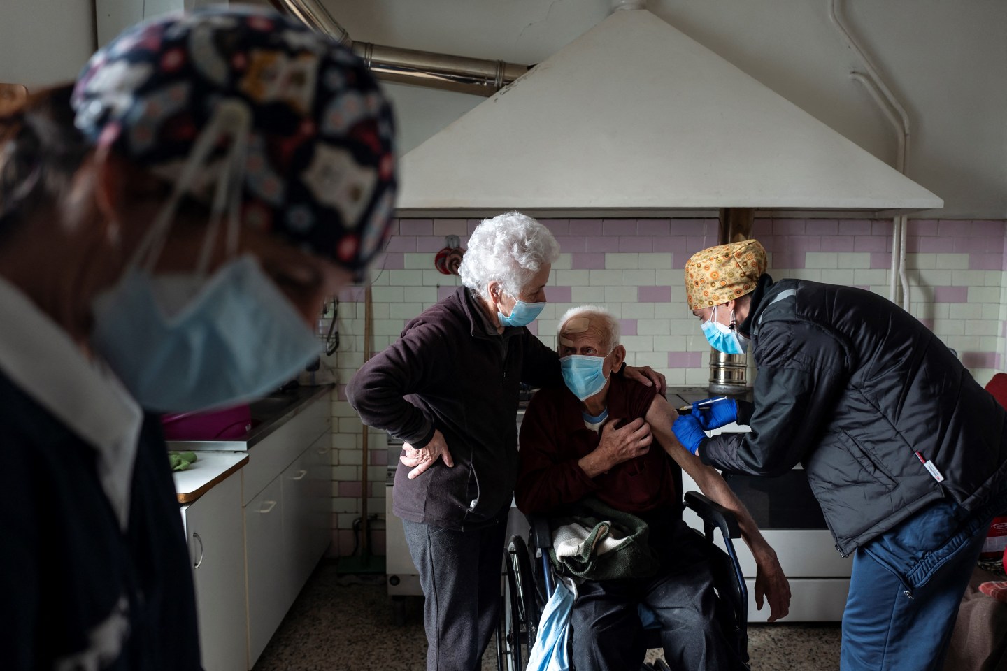 A medical worker vaccinates a man in Italy.