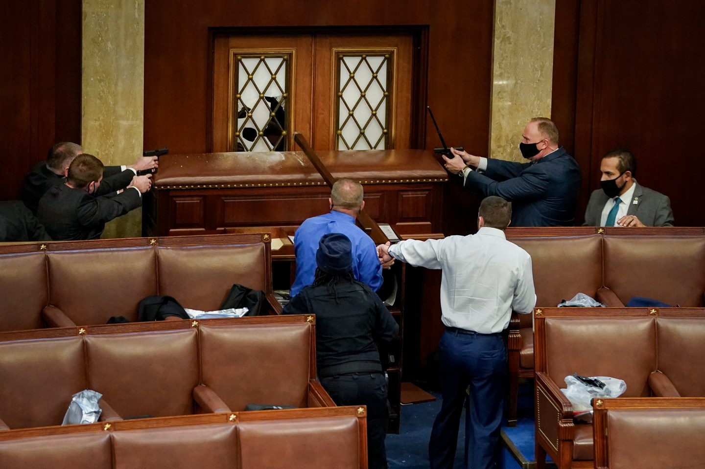 Law enforcement officers point their guns at the main door of the House Chamber as protestors attempt to enter the House Chamber during a joint session of Congress on January 06, 2021 in Washington, DC.
