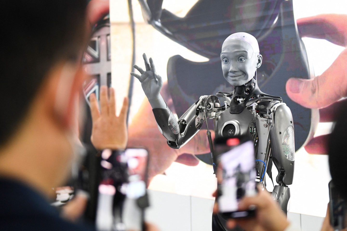 Attendees interact with the Engineered Arts Ameca humanoid robot during the Consumer Electronics Show (CES) on Jan. 5, 2022, in Las Vegas. “Companies should ensure that the productivity of both humans and A.I. rises as they work together, and that they bring out the best in each other,” the authors write.