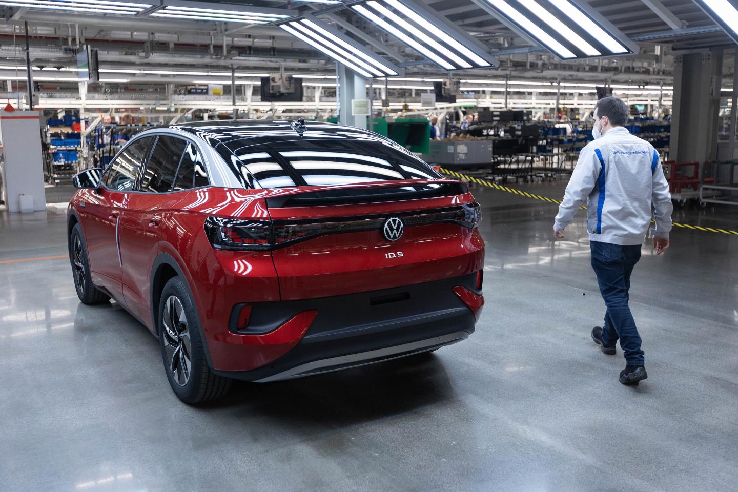 An employee checks a Volkswagen AG (VW) ID.5 electric sports utility vehicle (eSUV) in the light tunnel of the assembly line during a media tour of the automaker's electric automobile factory in Zwickau, Germany, on Thursday, Jan. 27, 2020