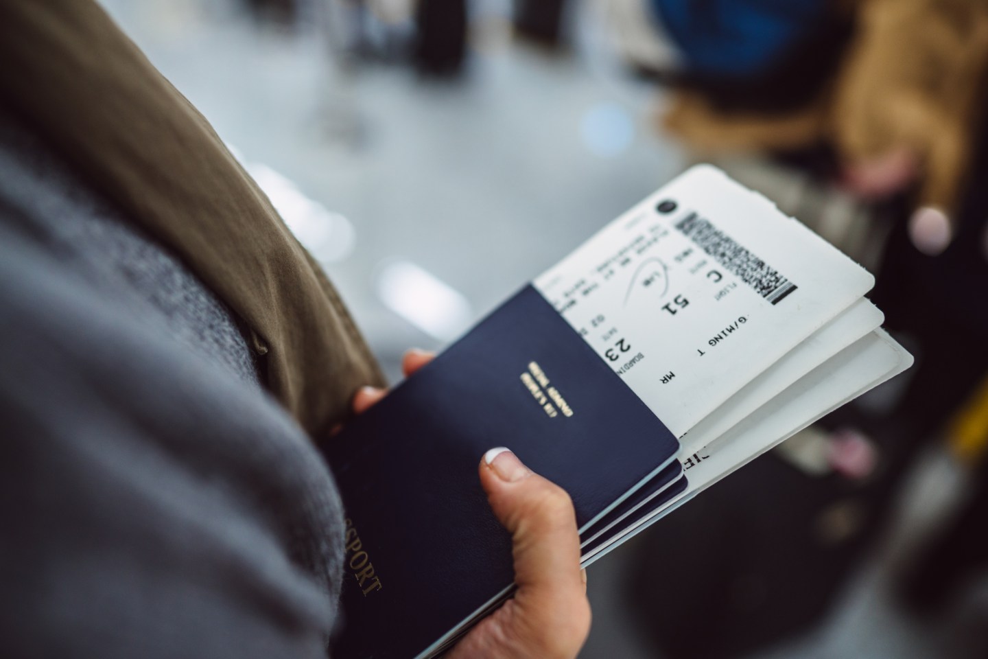 A traveler holds a passport and boarding passes