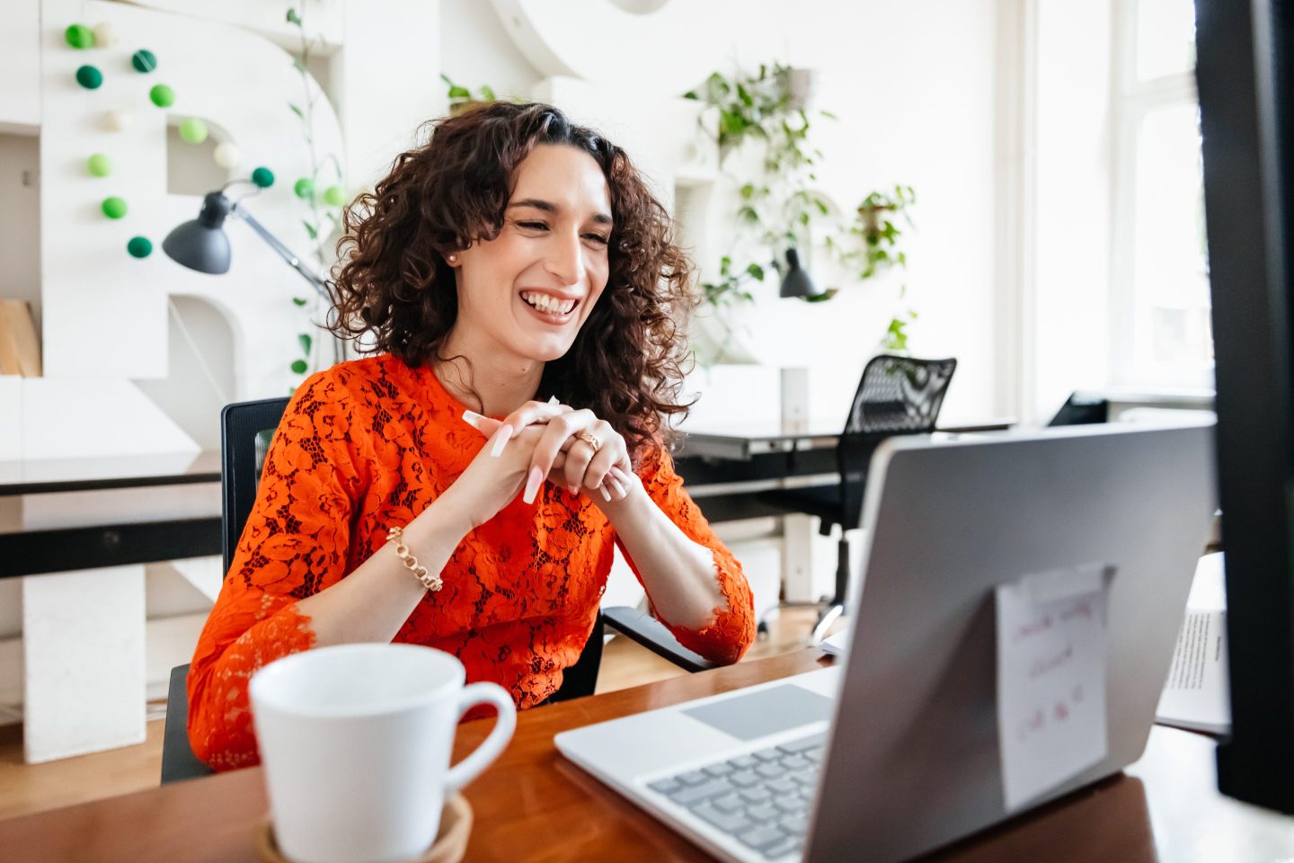 Woman smiles while working at her computer.