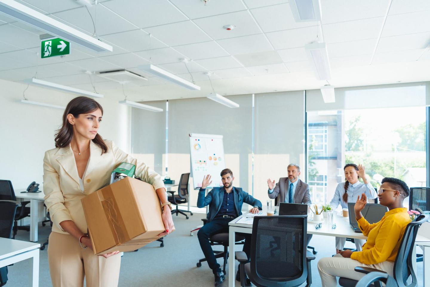 Shot of an unhappy businesswoman holding her box of belongings after getting fired from her job