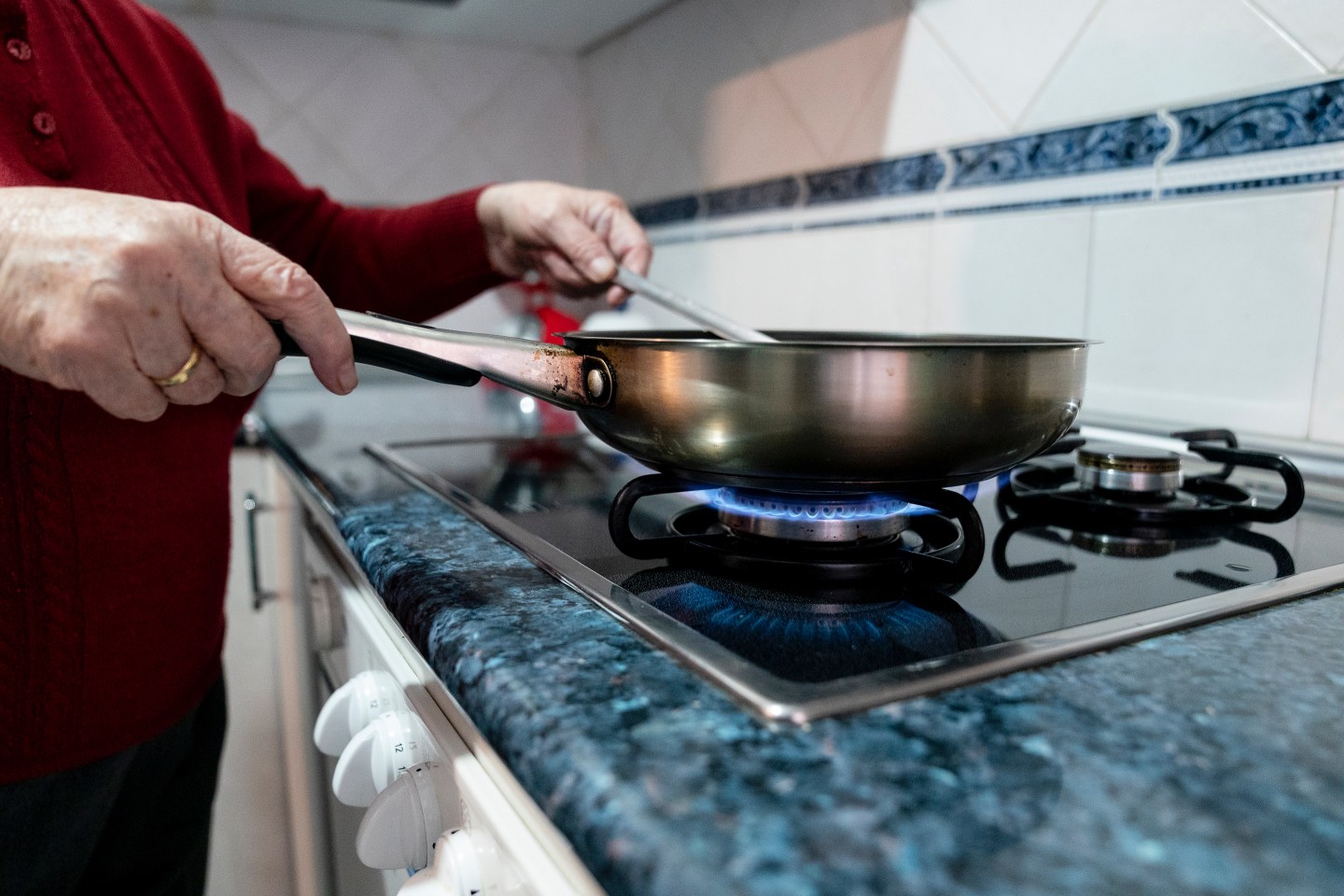 person cooking in pan on gas burner