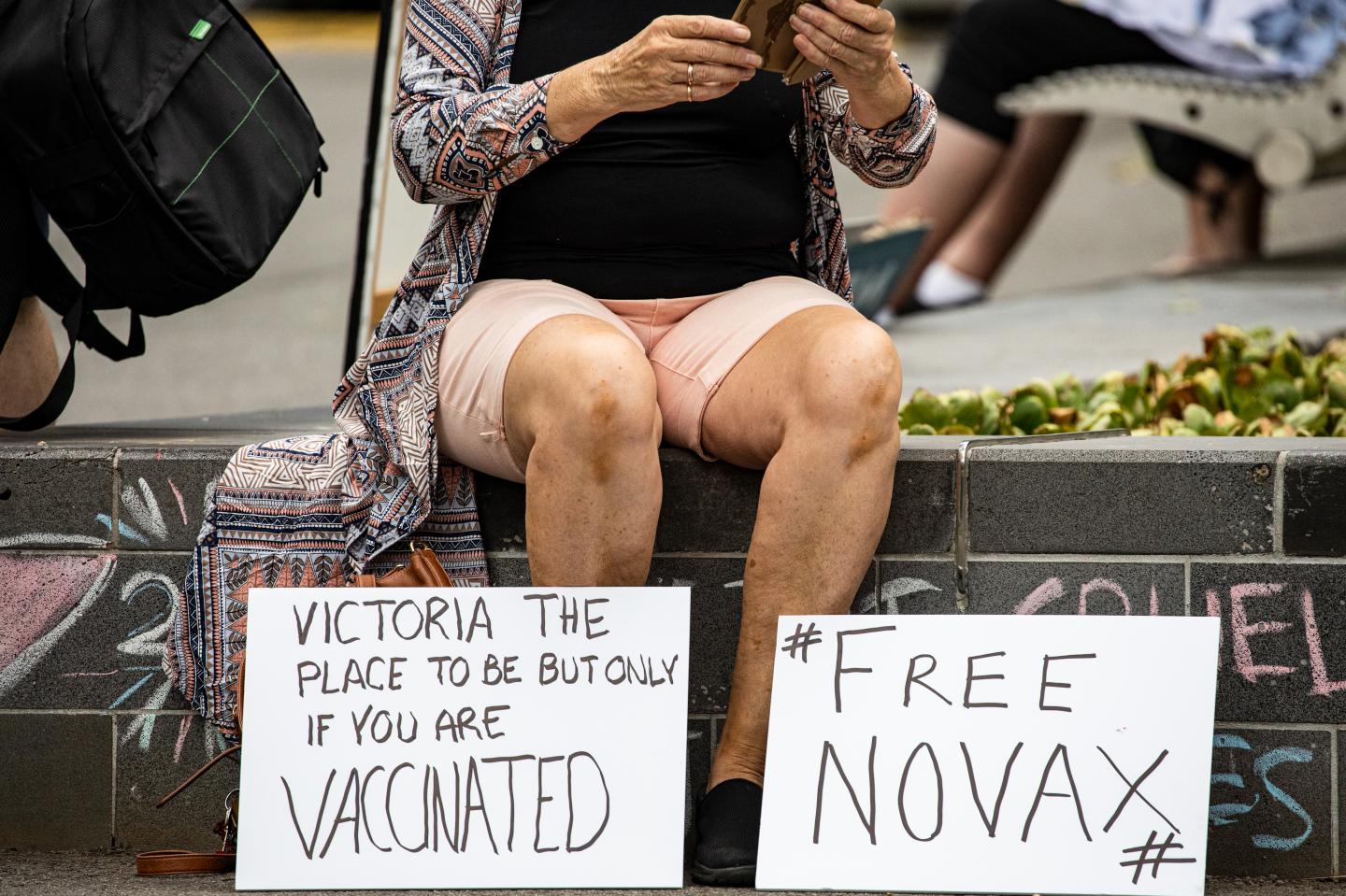 A Novak Djokovic supporter displays anti-vaccination signage as they gather outside Park Hotel where Djokovic was taken pending his removal from the country after his visa was cancelled by the Australian Border Force on January 06, 2022 in Melbourne, Australia.