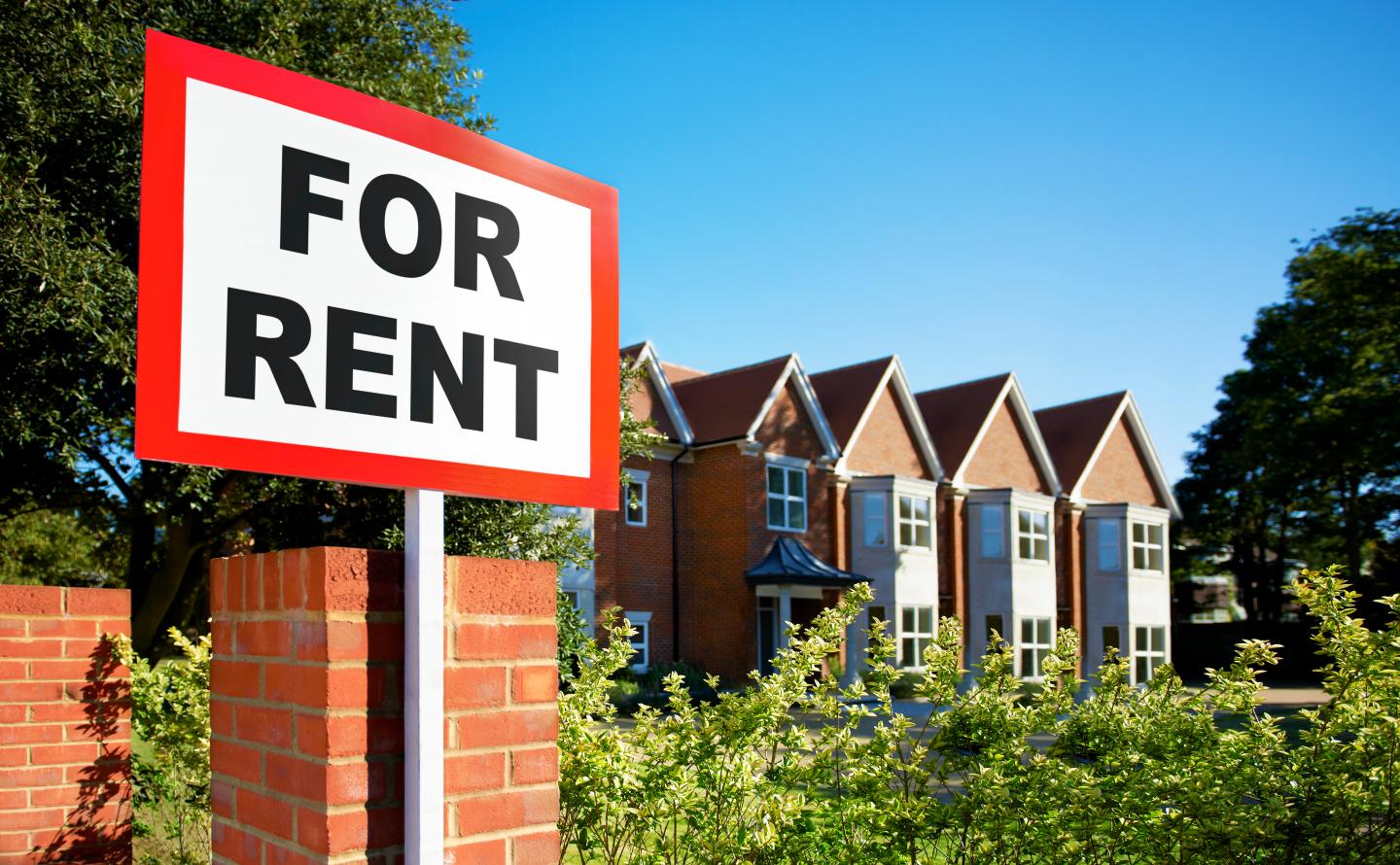 A for rent sign in front of an apartment building.