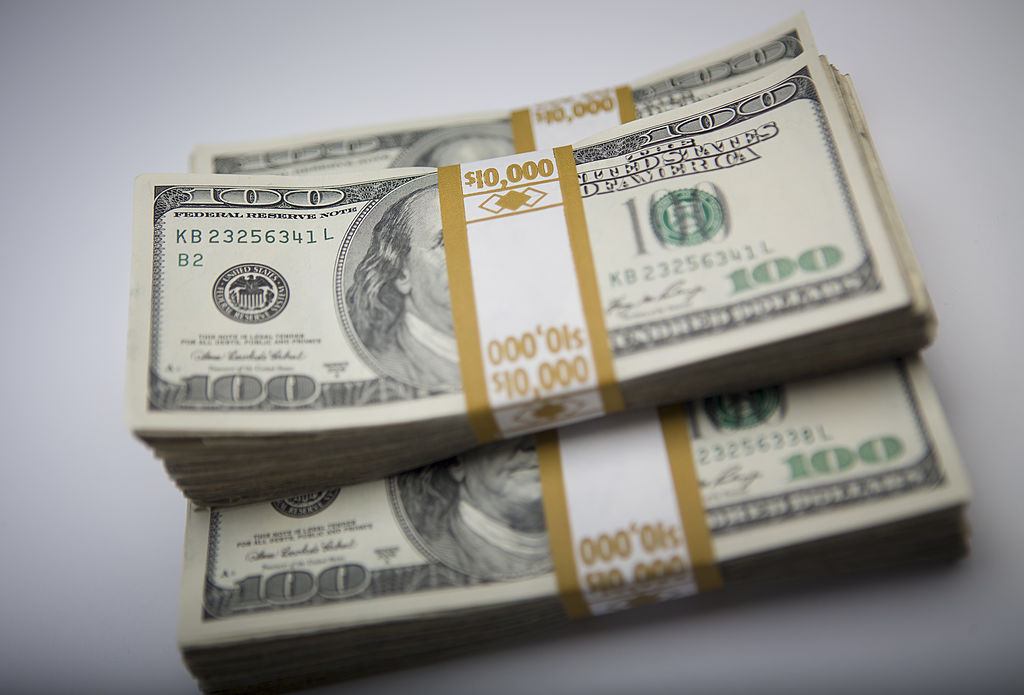 Three stacks of hundred-dollar bills