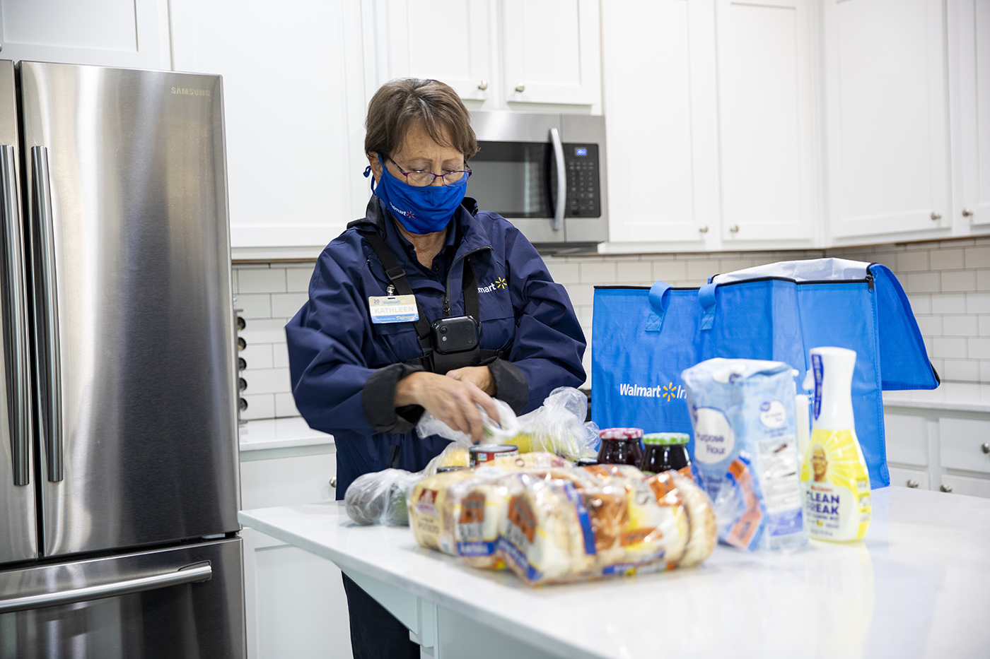 A Walmart employee making a grocery delivery.