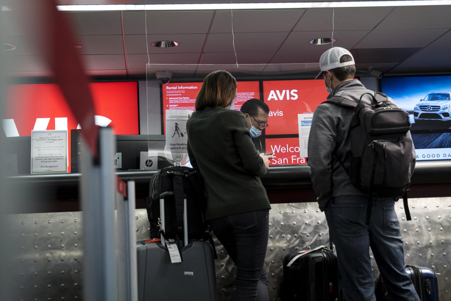 Customers wait at an Avis rental counter