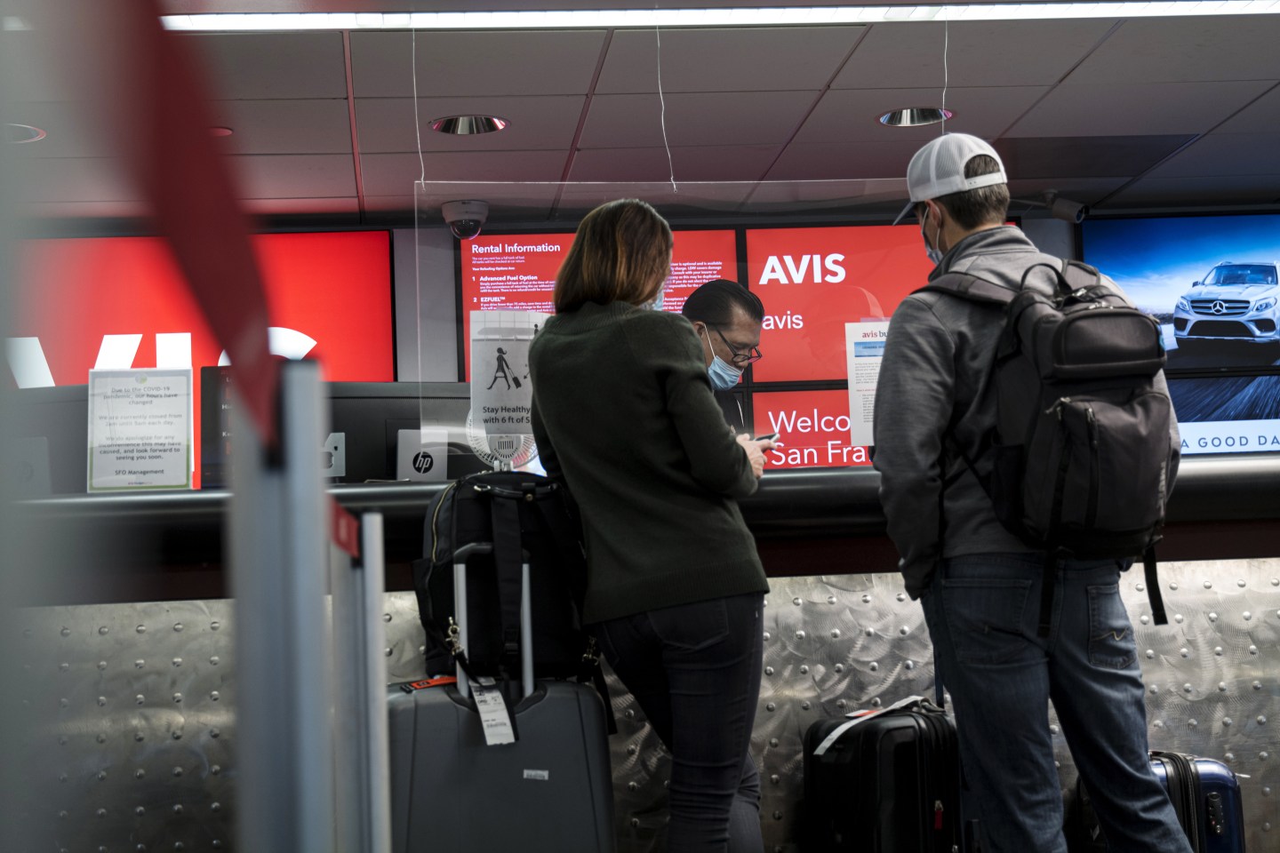 Customers wait at an Avis rental counter