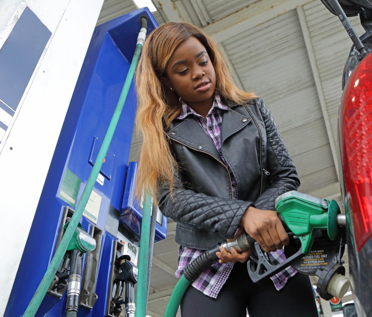 A woman fuels up her car with gasoline.