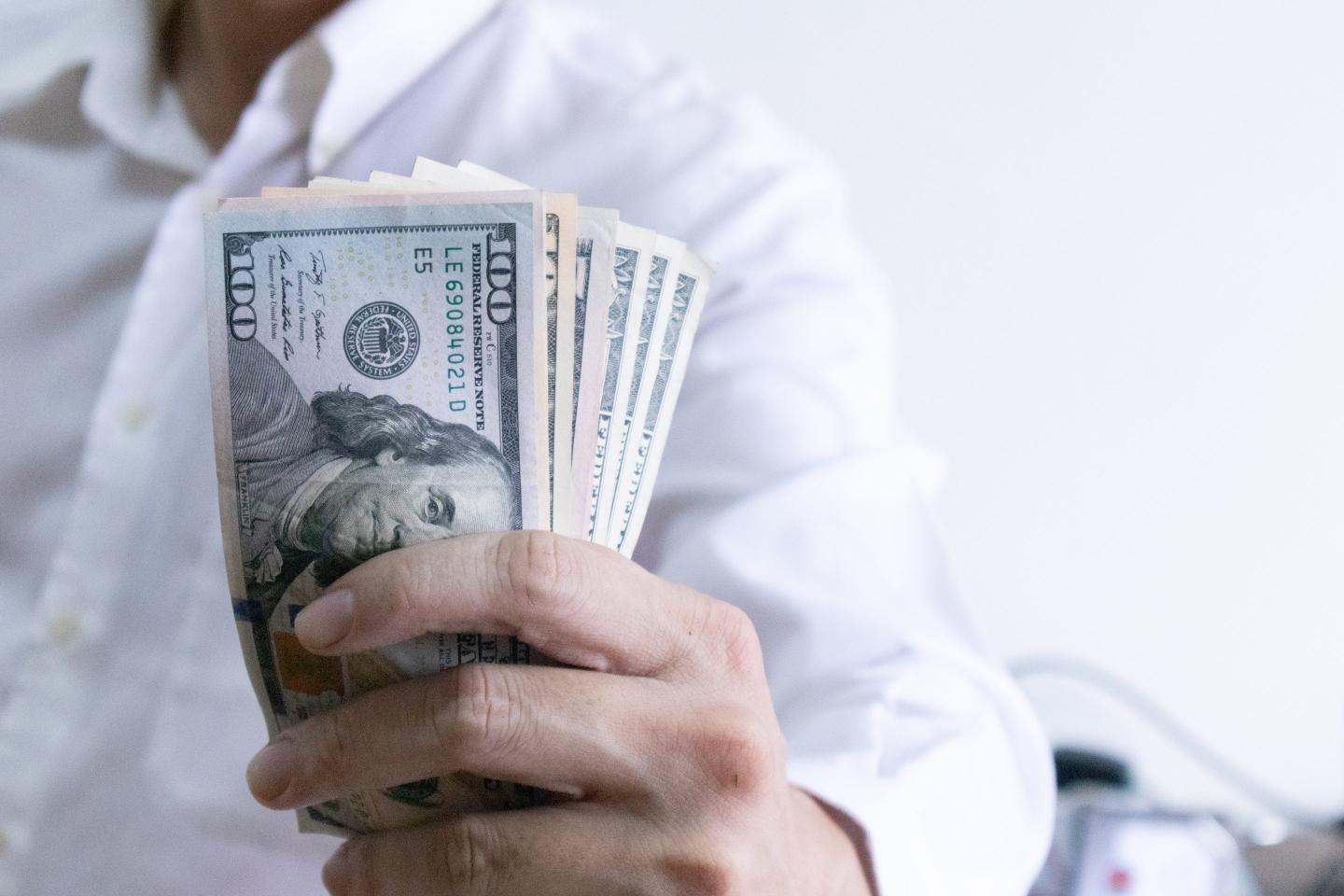 Businessman holding $100 bills