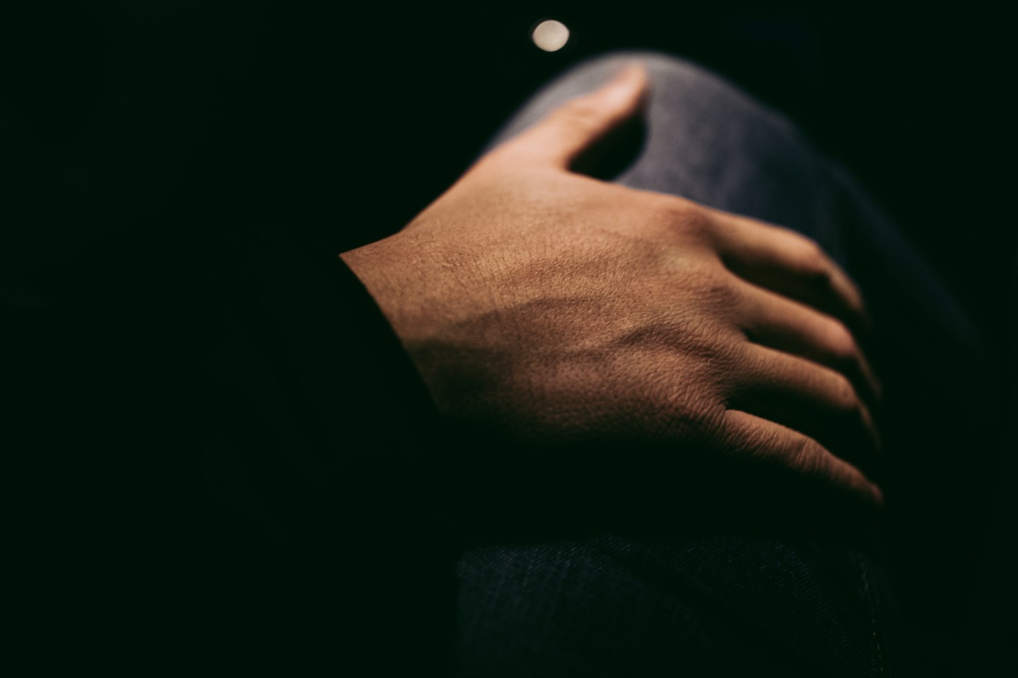 Man puts his hand on a woman's thigh by night