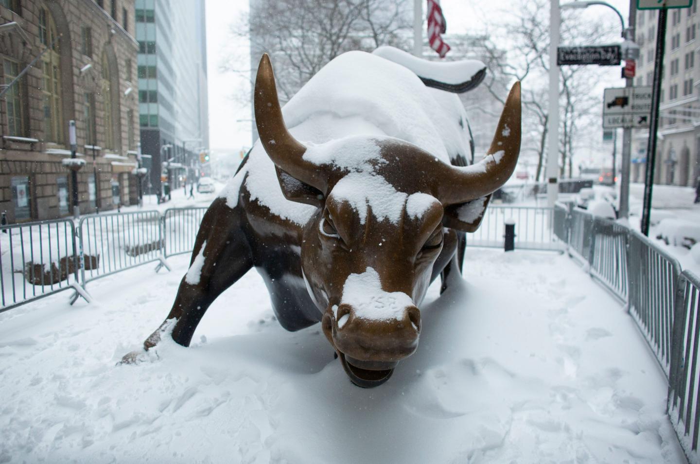 a photo of the wall street bull statue covered in snow