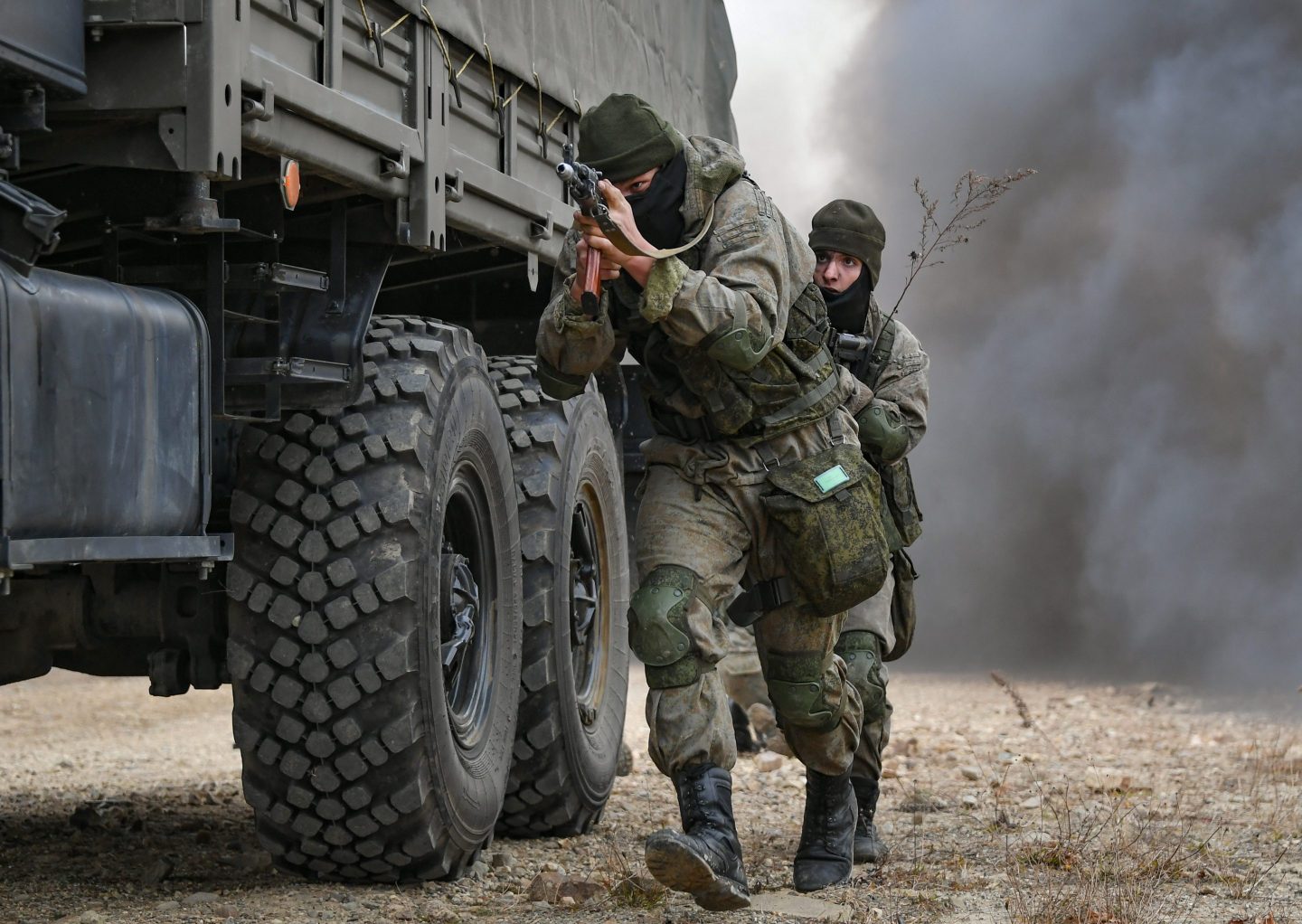 Russian soldiers with guns drawn during a military exercise.