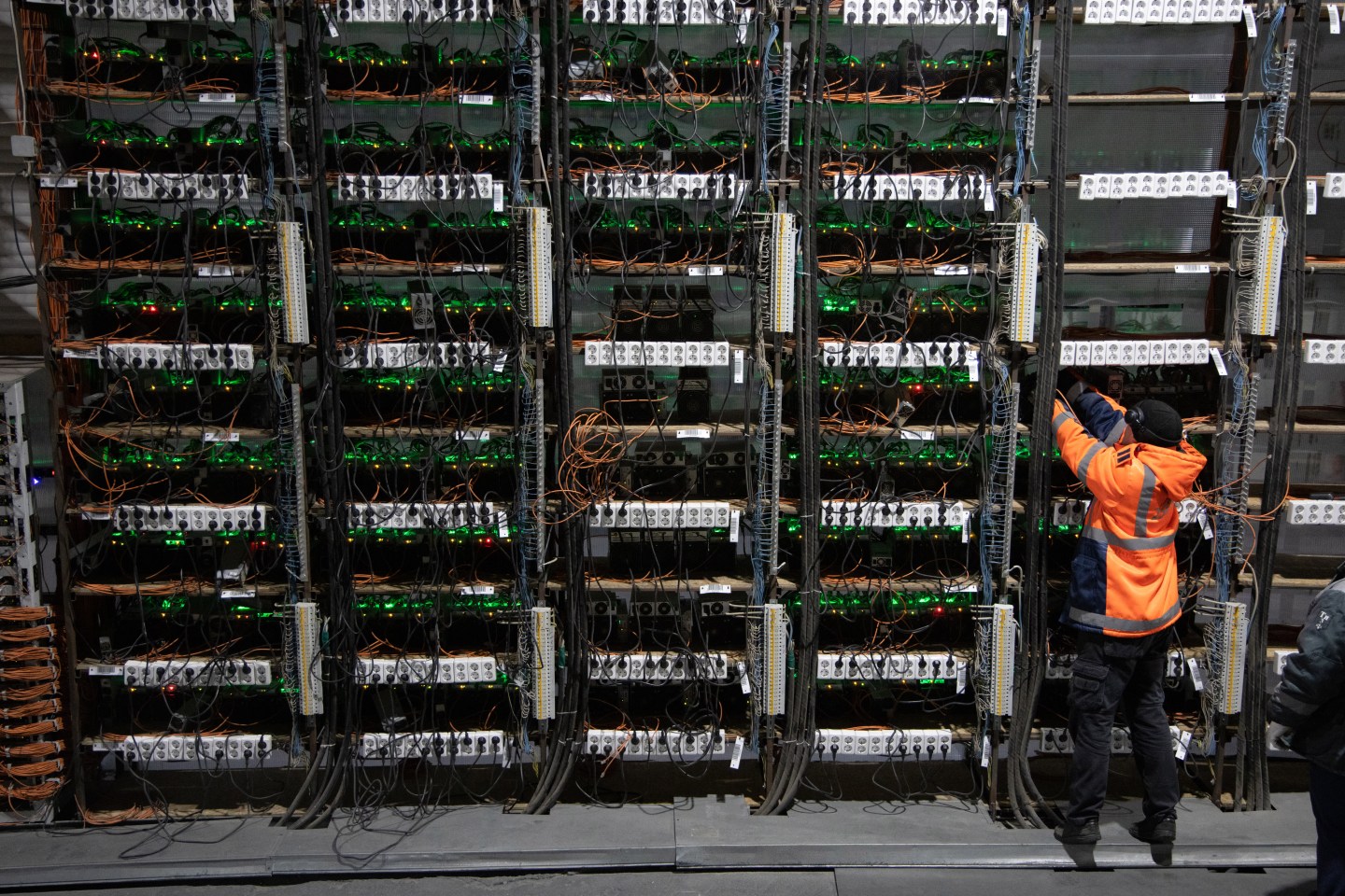 A technician installs new mining rigs at a cryptocurrency mining center.