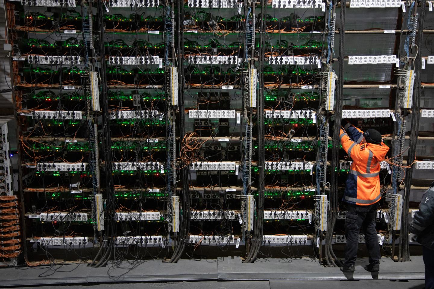 A technician installs new mining rigs at a cryptocurrency mining center.