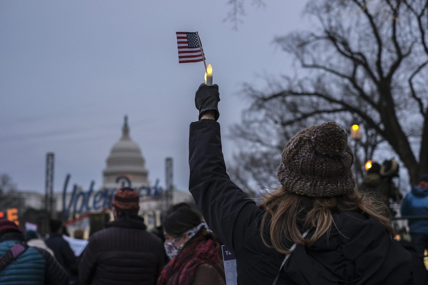 An activist holds up a candle and U.S. flag during a vigil near the U.S. Capitol