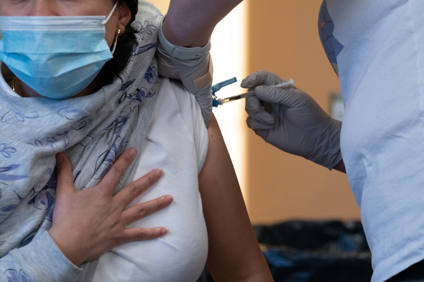 A health care worker administers a dose of COVID-19 vaccine in Massachusetts