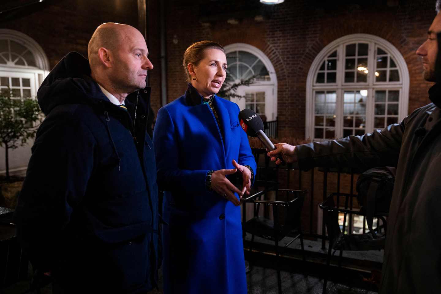 Denmark's Prime Minister Mette Frederiksen (R) and chairman of the Conservative People's Party Soren Pape Poulsen speak to journalists as they meet and eat together at the Price Brothers Restaurant in Copenhagen on February 1, 2022, as Denmark becomes the first EU country to lift coronavirus restrictions despite record case numbers, citing its high vaccination rates and the lesser severity of Omicron variant.