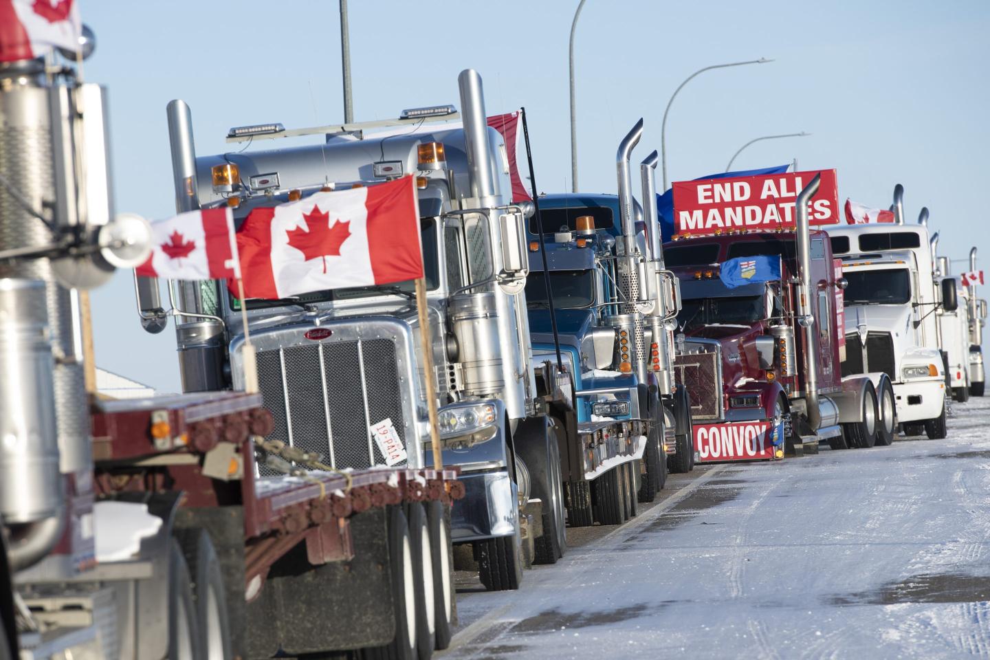 Lines of trucks block the U.S.-Canada border during a demonstration in Coutts, Alberta, Canada, on Wednesday, Feb. 2, 2022.