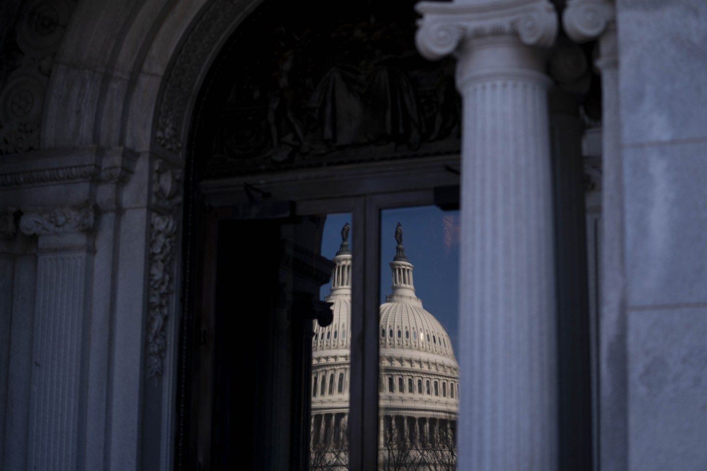 The U.S. Capitol dome is reflected in a window of the Library of Congress in Washington, D.C.