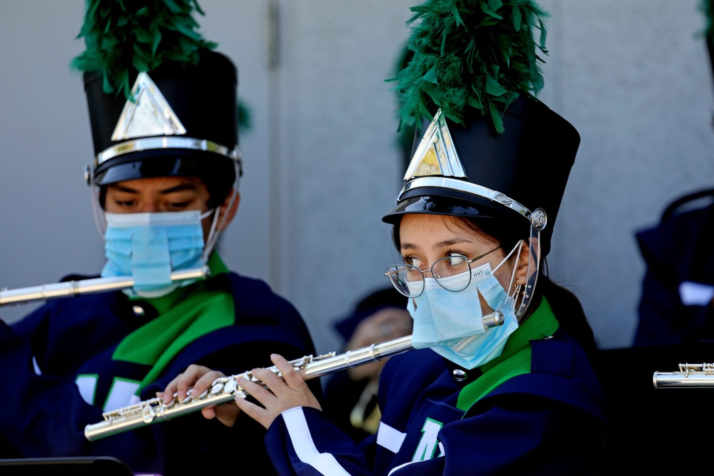 Girl playing flute with mask on