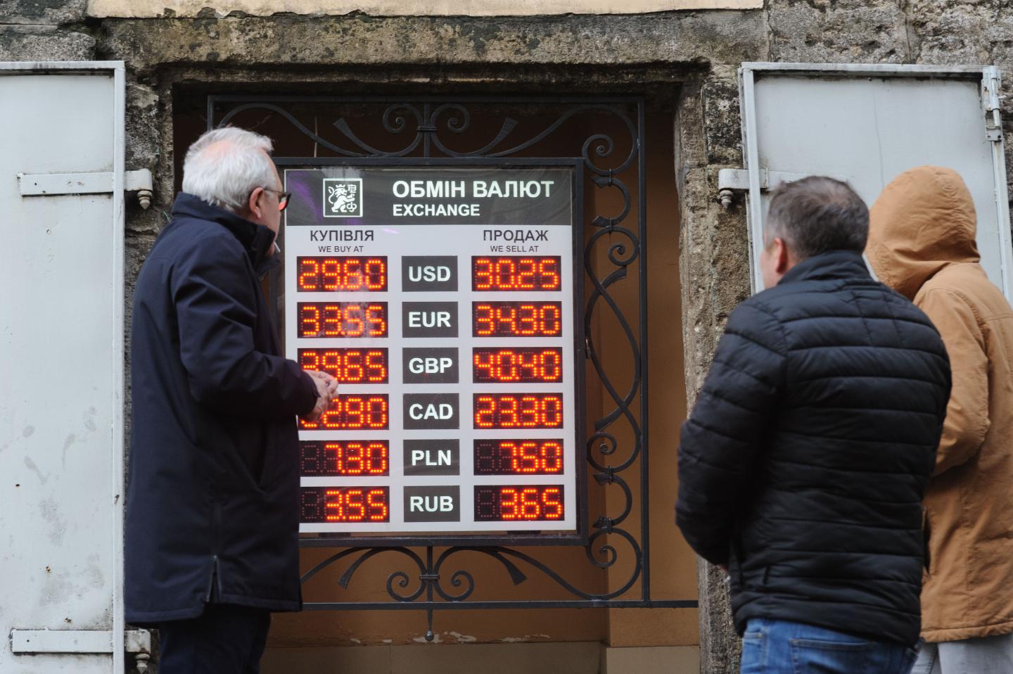 Men looking at currency conversion rates.