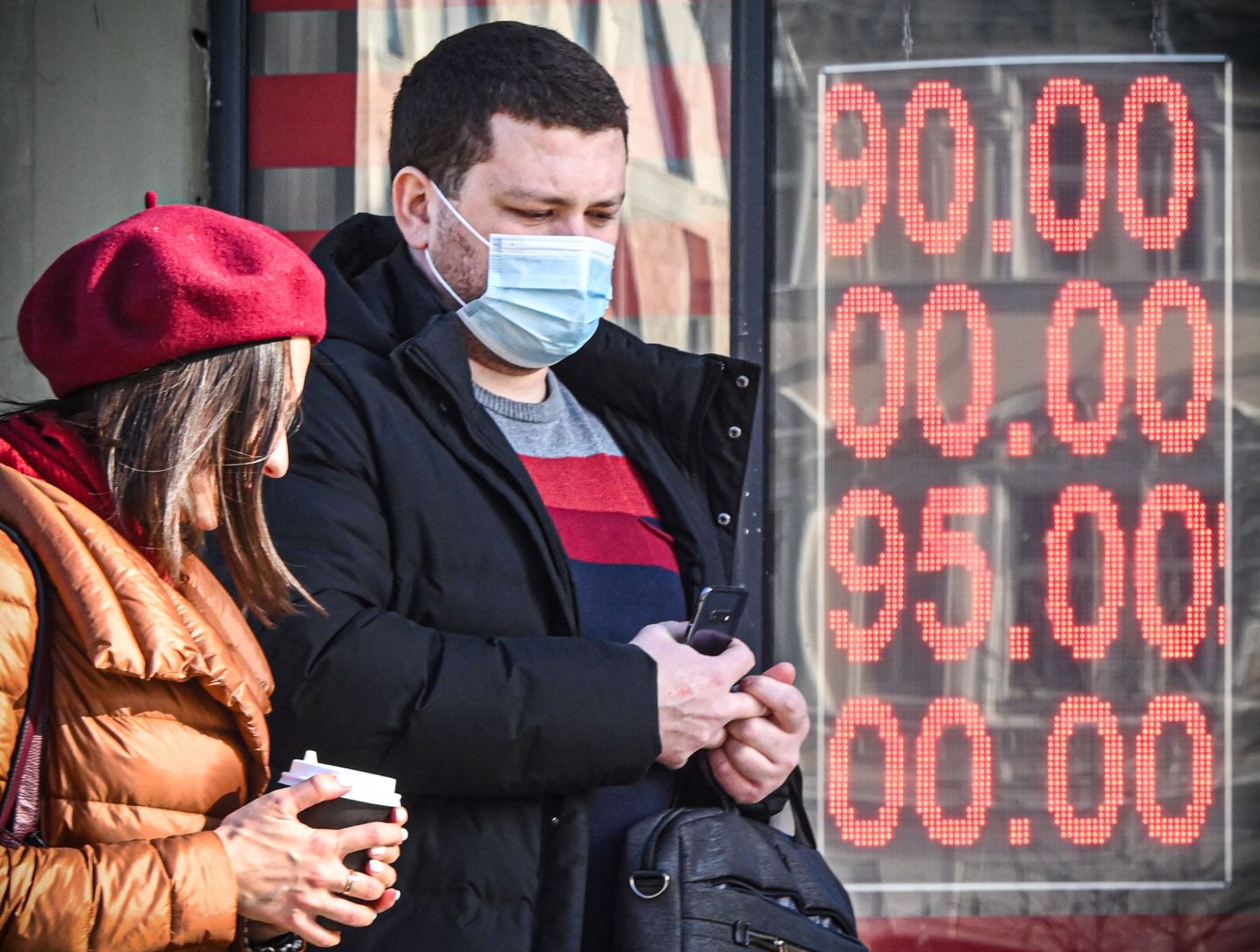 People walk past a currency exchange in Moscow.