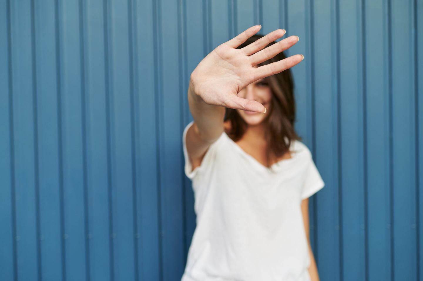 Portrait of a woman covering her face with her hand